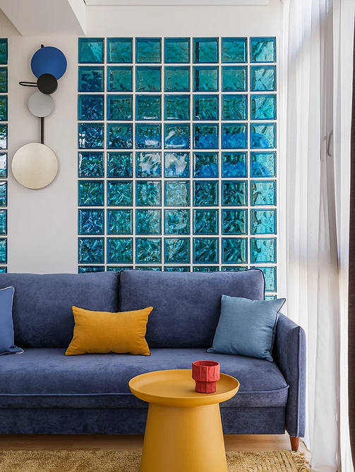 Елегантний синій диван з оксамитовою оббивкою в класичному інтер'єрі кімнати.