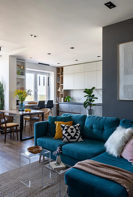 Інтер'єр з синім диваном, жовтим кріслом та декоративними рослинами