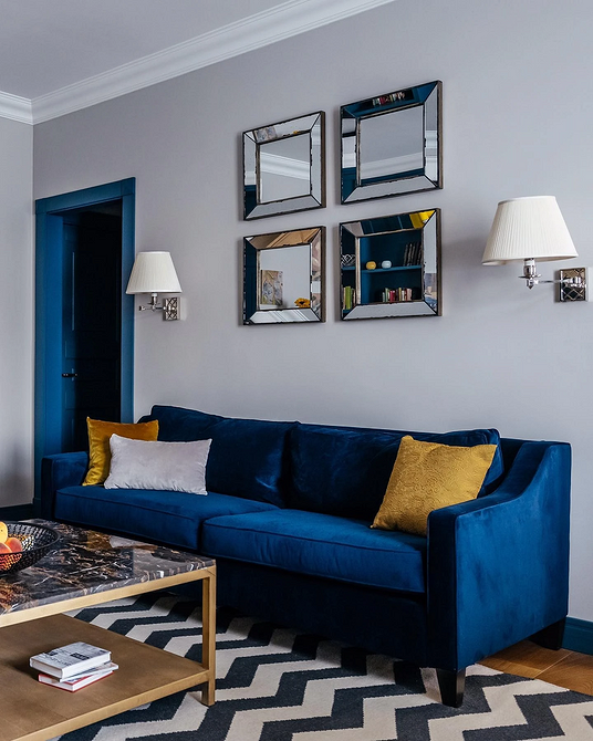 Інтер'єр вітальні з синім диваном, світлі стіни та дерев'яна підлога