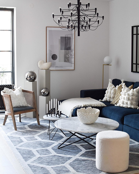 Вітальня з синім кутовим диваном, панорамними вікнами та видом на місто.