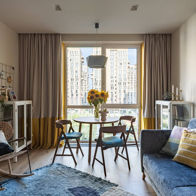 Інтер'єр кімнати з великим синім диваном та панорамними вікнами