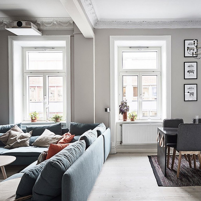 Синій диван в еклектичному інтер'єрі з різноманітними текстурами та кольорами, що створює унікальний простір.