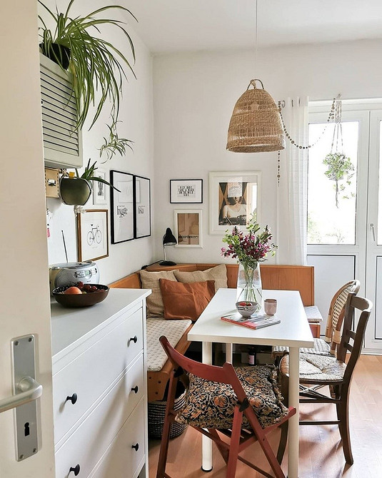 Сучасний кухонний куточок з диваном та обіднім столом для економії простору.