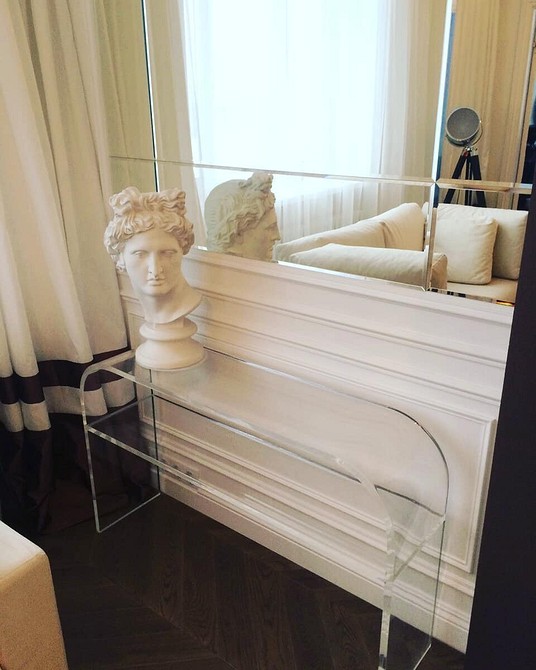 Прозорі стільці навколо обіднього столу, сучасний дизайн інтер'єру кухні.