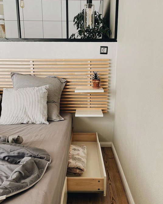 Стильна спальня з ліжком з великим узголів'ям, що підкреслює сучасний дизайн.