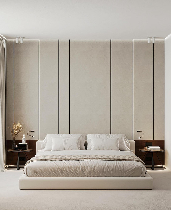 Сучасне ліжко з великим узголів'ям та декоративними подушками в світлій спальні.