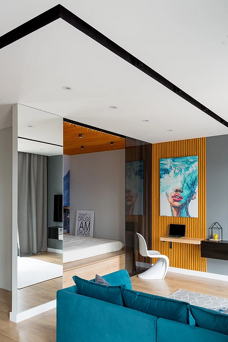 Сучасна спальня з ліжком-подіумом, поєднаним з робочим місцем, зонування простору.