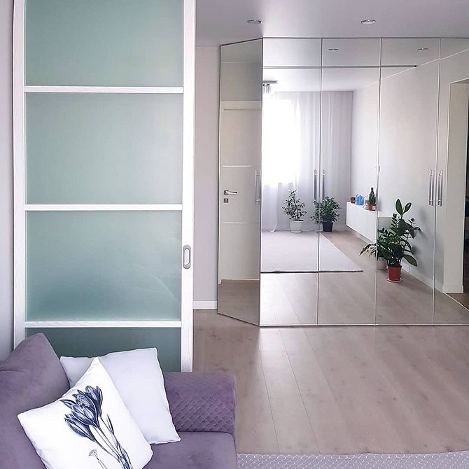 Вітальня з кутовою дзеркальною шафою: ергономічне рішення для невеликих приміщень.