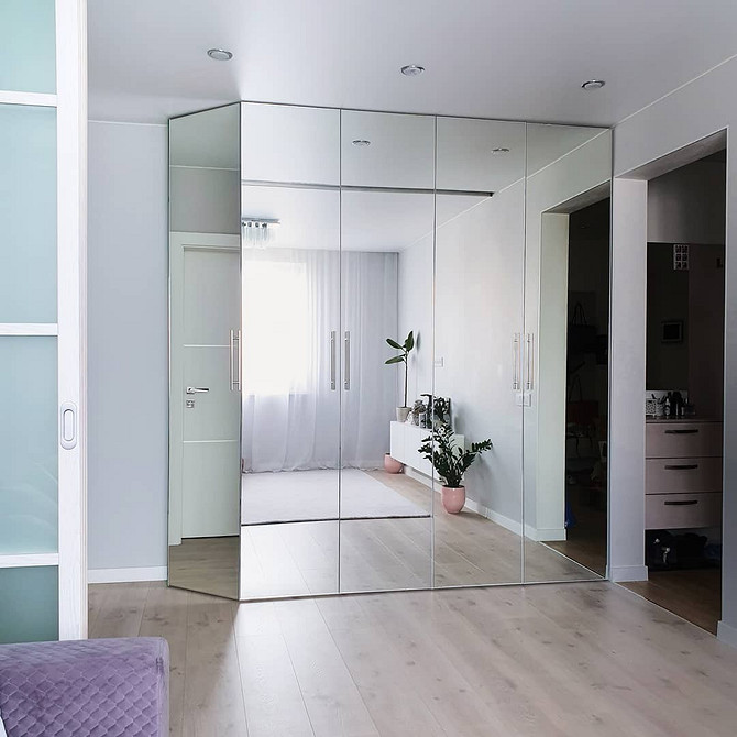 Інтер'єр вітальні з дзеркальною шафою: світлий простір завдяки відображенню світла.