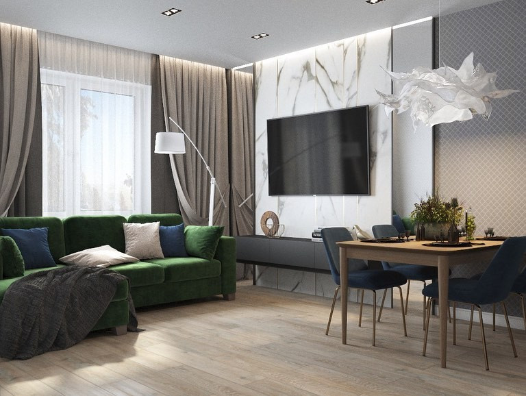 Затишна вітальня з зеленим диваном, декоративними подушками та теплим освітленням.