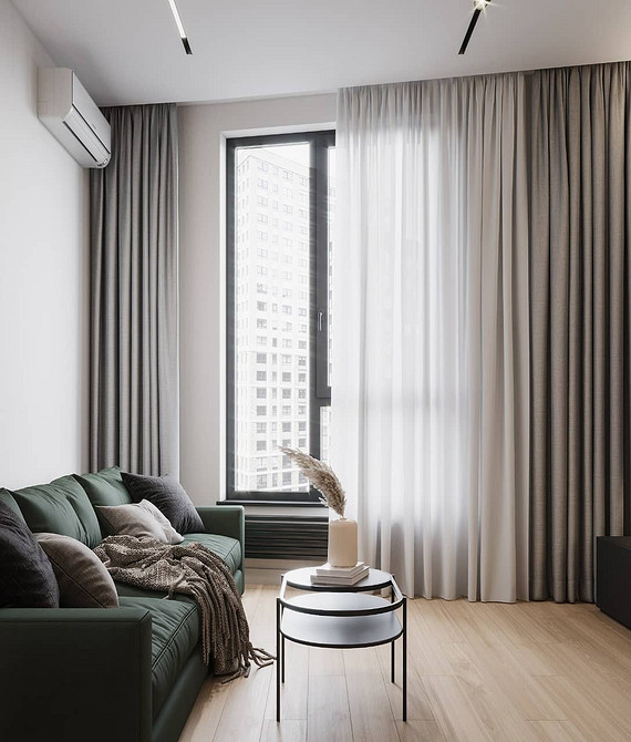 Інтер'єр вітальні з зеленим диваном, шторами та килимом в єдиній колірній гамі.