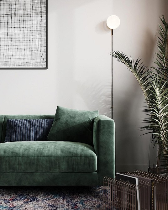 Зелений диван в скандинавському стилі з дерев'яними ніжками та текстильними подушками.