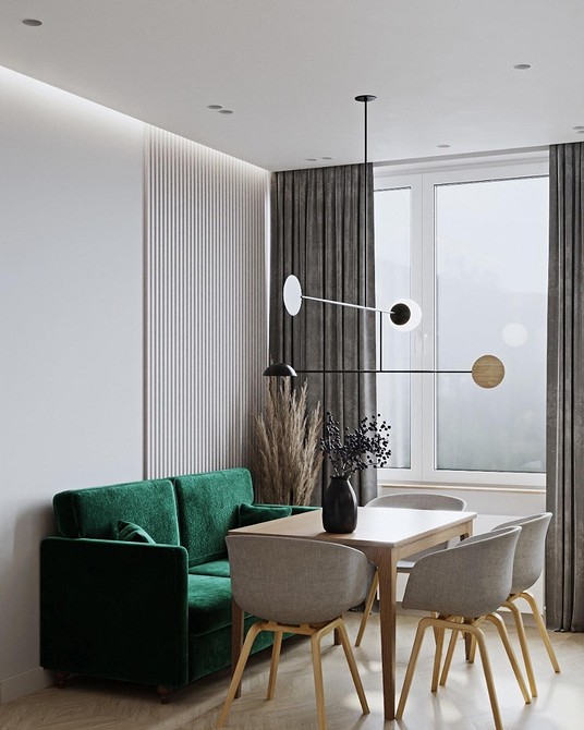 Темно-зелений шкіряний диван у вітальні з каміном та книжковими полицями.