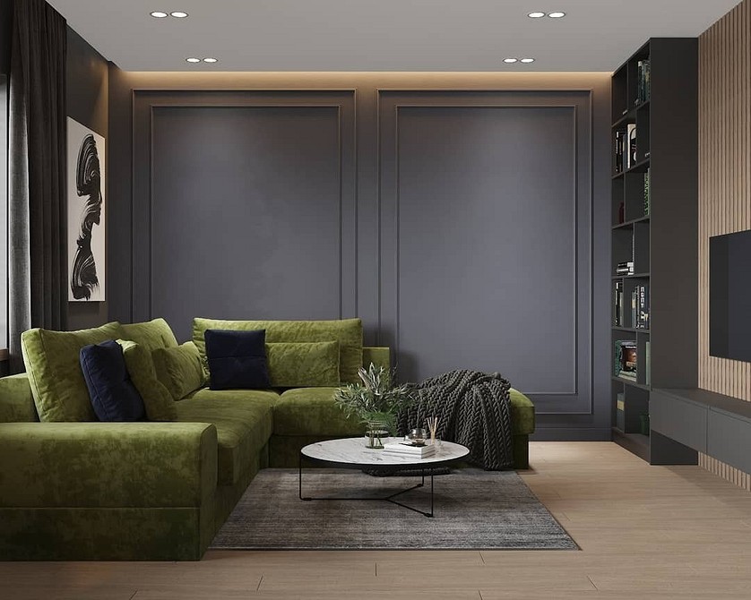 Дизайн вітальні з двома зеленими диванами та килимом з геометричним візерунком.