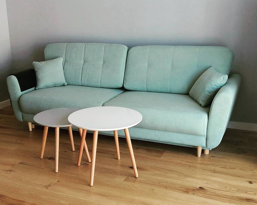 Інтер'єр вітальні з салатовим диваном та декоративними подушками різних кольорів.