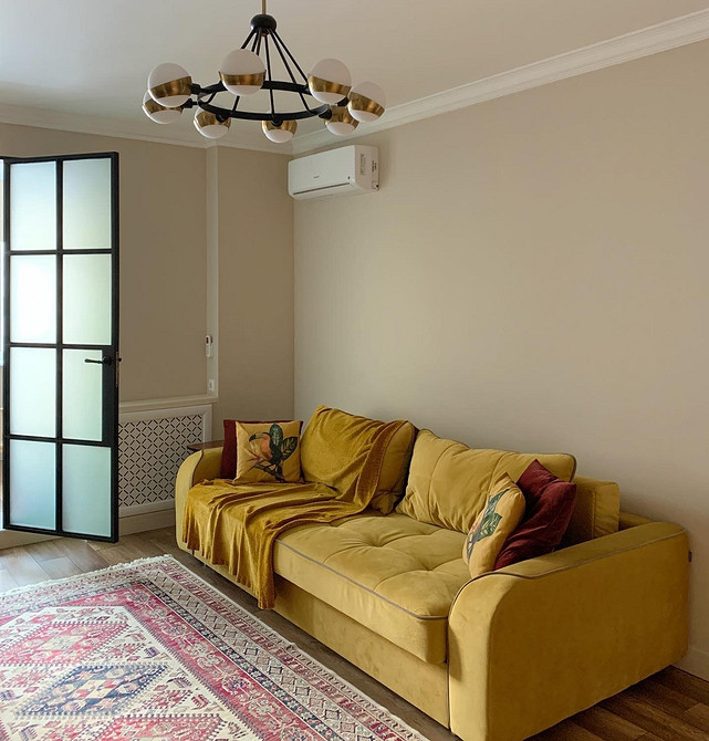 Жовтий диван у дитячій кімнаті з іграшками та яскравими елементами декору