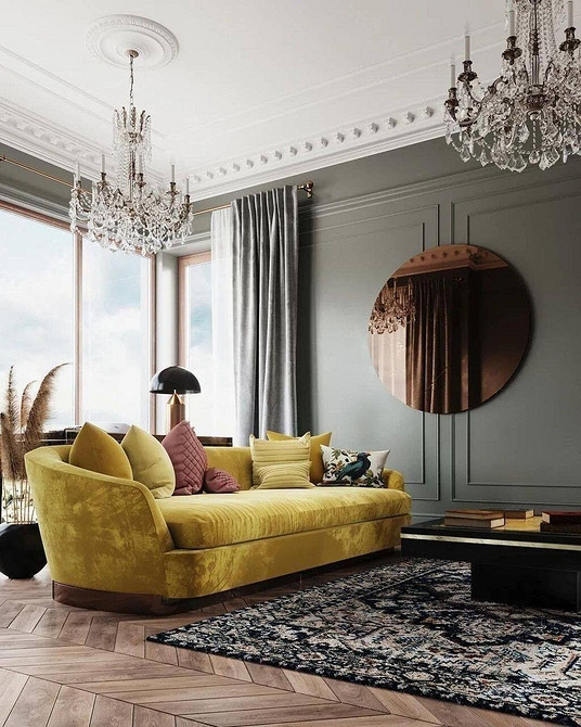 Елегантний жовтий диван в інтер'єрі з сірими стінами, картинами та декоративними елементами.
