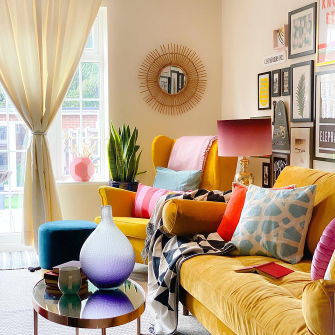 Дизайн вітальні з жовтим диваном та декоративними подушками різних кольорів