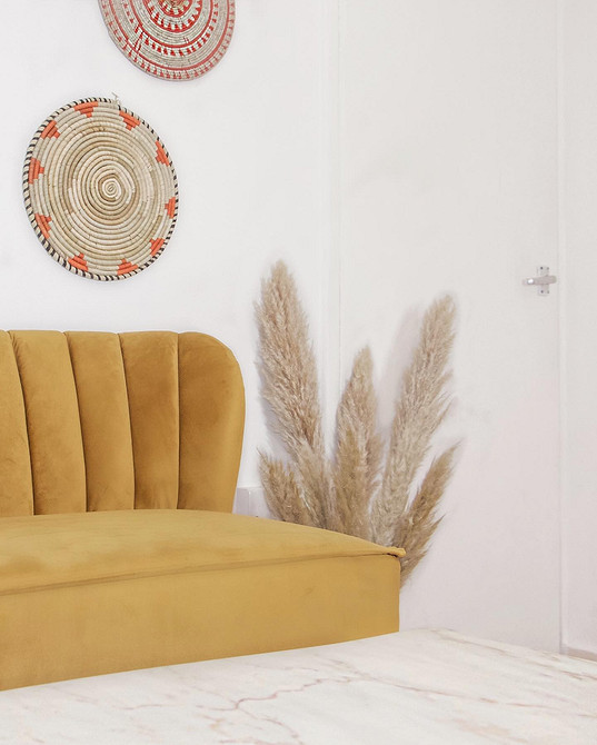 Сучасний інтер'єр вітальні з жовтим диваном та килимом з геометричним візерунком