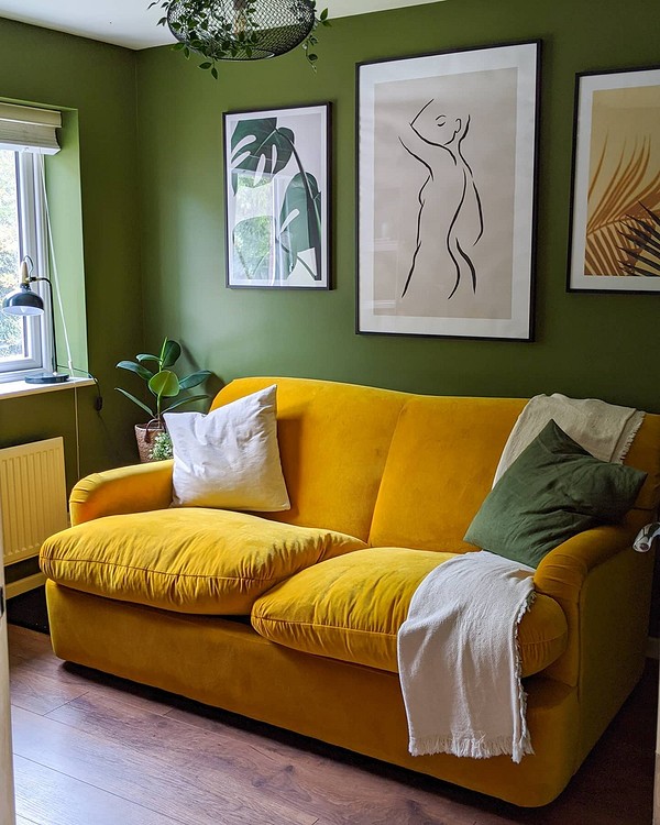 Жовтий велюровий диван з декоративними подушками в інтер'єрі у стилі бохо