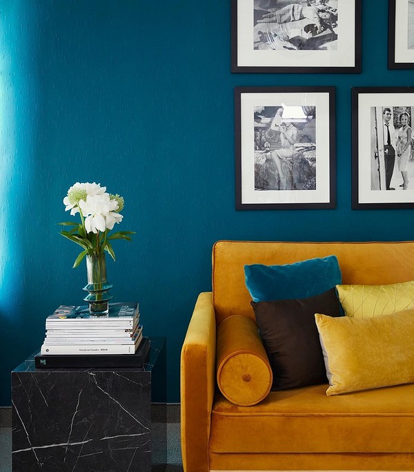 Жовтий диван в інтер'єрі вітальні з сірими стінами та декоративними подушками.