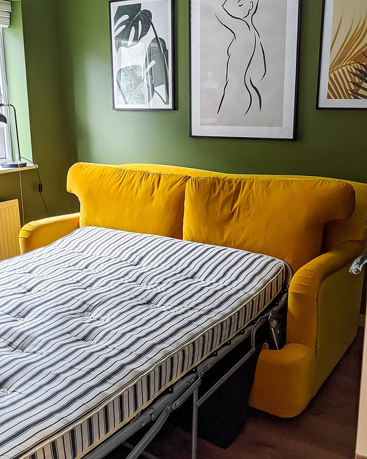 Жовтий диван у скандинавському інтер'єрі з рослинами та дерев'яними елементами