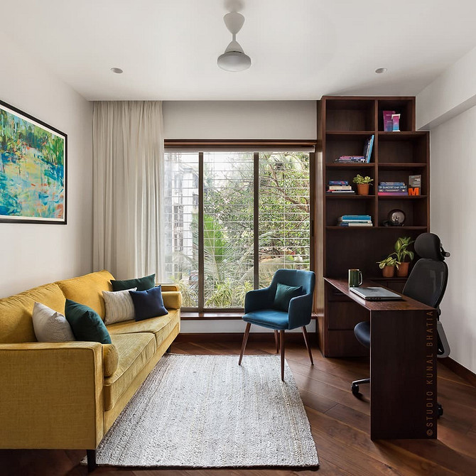 Жовтий диван з геометричними подушками у вітальні з сучасним дизайном та декором.