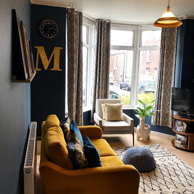 Жовтий шкіряний диван в класичному інтер'єрі з темними меблями та книгами.