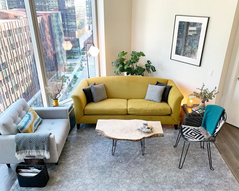 Стильний жовтий диван в інтер'єрі з використанням сірих та білих кольорів.