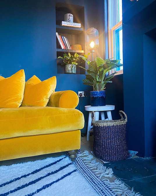 Невеликий жовтий диванчик в дитячій кімнаті з іграшками та декором.