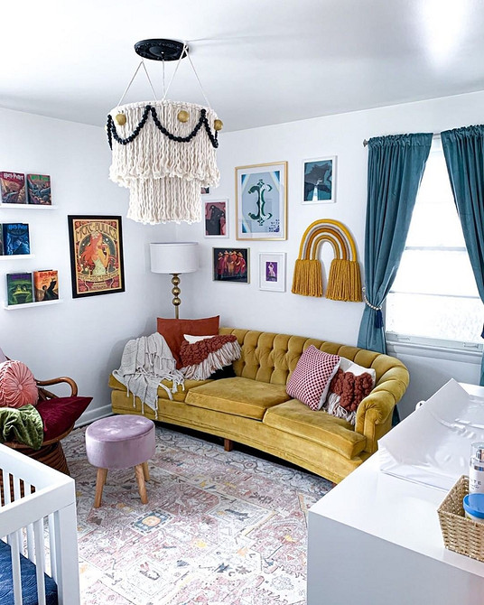 Жовтий диван в поєднанні з синіми стінами та картинами в сучасній вітальні