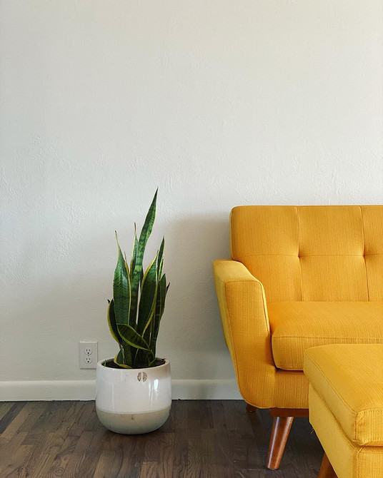 Жовтий диван у дитячій кімнаті з яскравими іграшками та декоративними елементами