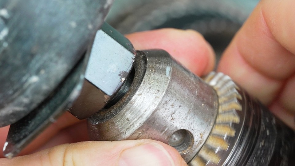 Відкручування гвинта патрона Процес відкручування гвинта, що фіксує патрон дриля на валу.