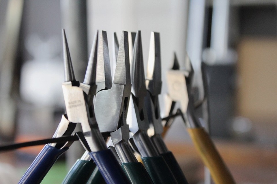 Інструменти під рукою Пасатижі та плоскогубці на робочому столі: готовність до виконання різноманітних завдань.