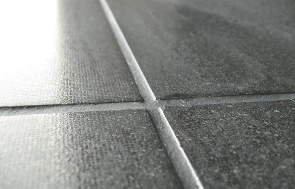 Нанесення затирки на плитку Нанесення цементної затирки шпателем на шви між плитками.