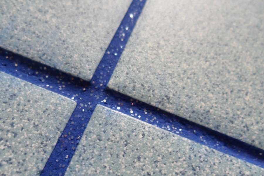 Затирка швів у ванній Процес цементної затирки швів плитки у ванній кімнаті.