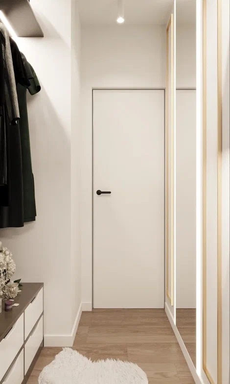 Єдність кольору Фарбовані двері прихованого монтажу, що зливаються зі стіною в сучасному мінімалістичному інтер'єрі.