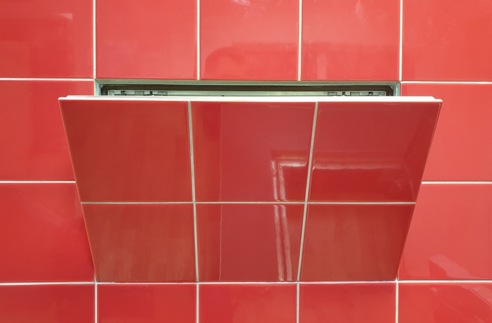 Люк-невидимка в інтер'єрі Сучасний ревізійний люк прихованого монтажу під плитку, інтегрований у дизайн ванної.