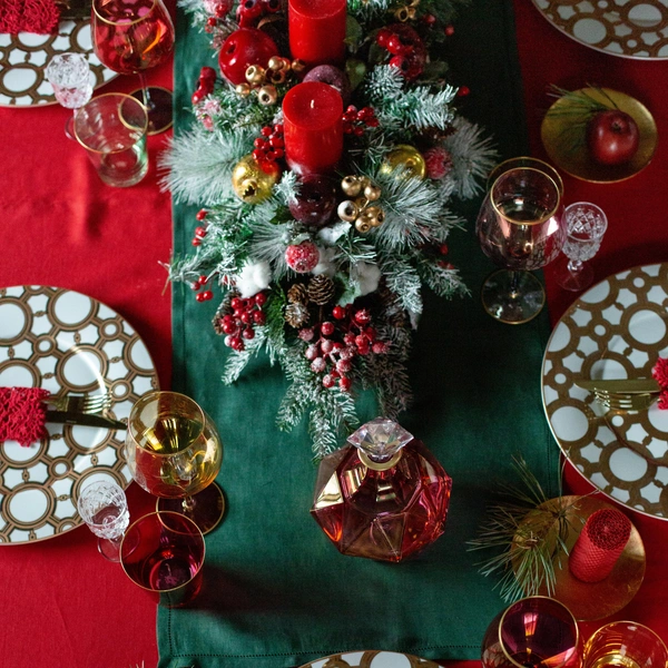 Святковий стіл: червоний та зелений Елегантна сервіровка новорічного столу 2026 з червоними та зеленими акцентами, що створює святкову атмосферу.