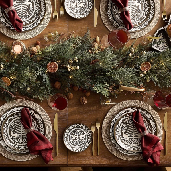 Гармонія кольорів Сервірування новорічного столу 2026: червоні та зелені тарілки, золоті прибори.