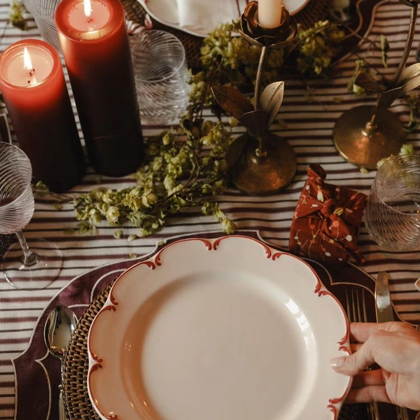 Елегантність свята Затишне сервірування новорічного столу 2026 з червоними серветками та золотим посудом.